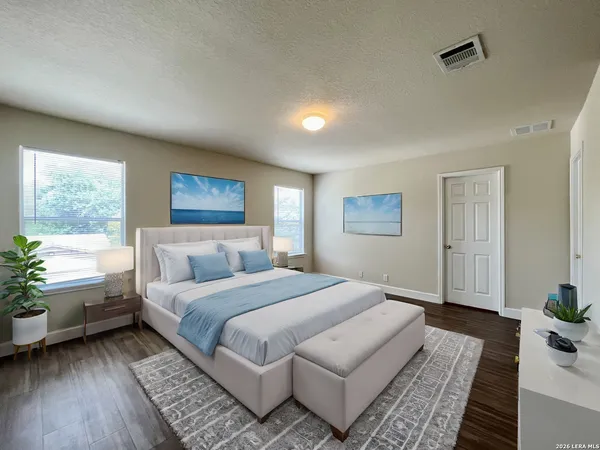 a spacious bedroom with a large bed a rug and a window
