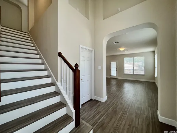 a view of a hallway with wooden floor and staircase