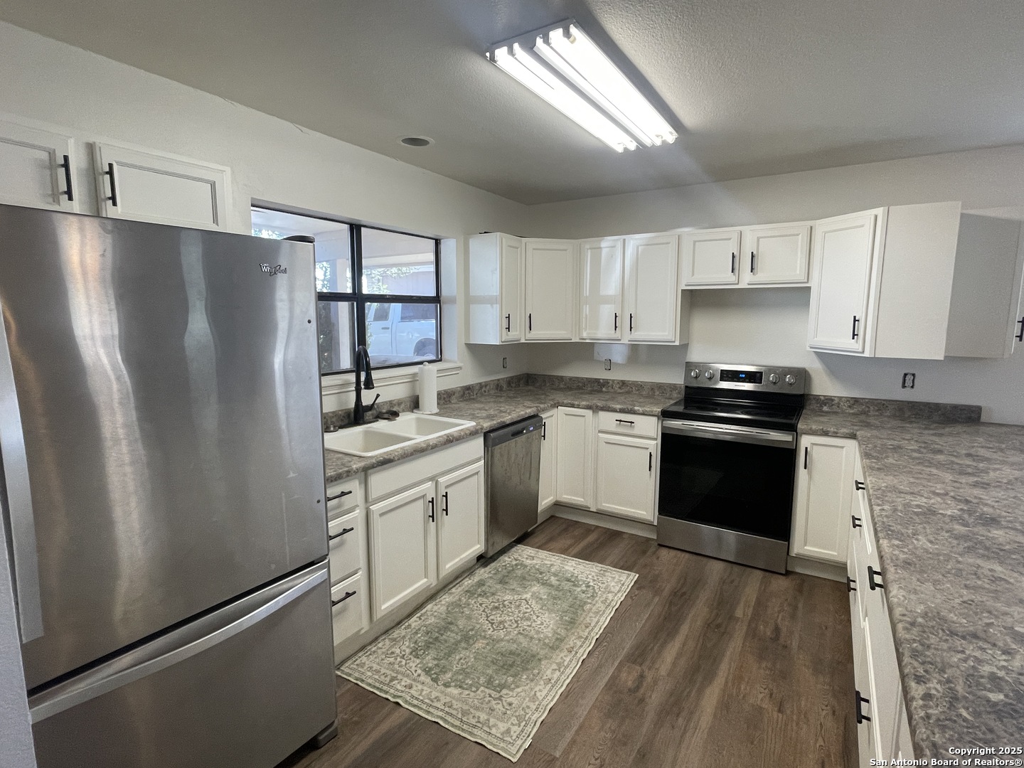 1408 33rd Street Hondo, TX 78861 - Photo 6 of 19 a kitchen with a refrigerator stove and sink