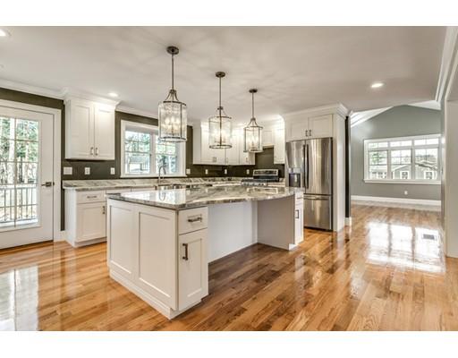 7 Tremlett Road Billerica, MA 01821 - Photo 5 of 30 a kitchen with stainless steel appliances kitchen island granite countertop a stove a refrigerator a sink dishwasher and white cabinets with wooden floor