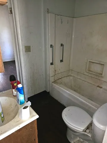 a bathroom with a granite countertop toilet and a sink