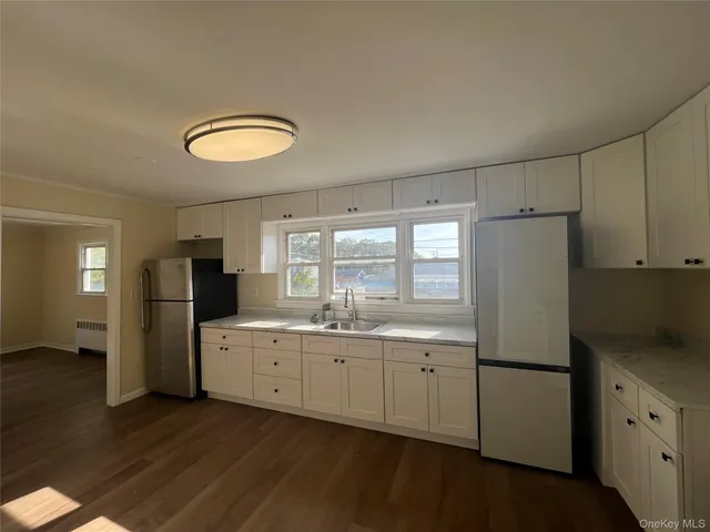 a kitchen with a refrigerator sink and cabinets