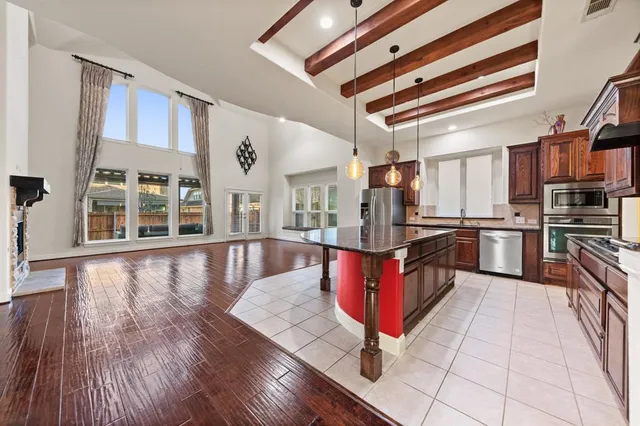 a kitchen with stainless steel appliances kitchen island granite countertop a stove a sink and a refrigerator