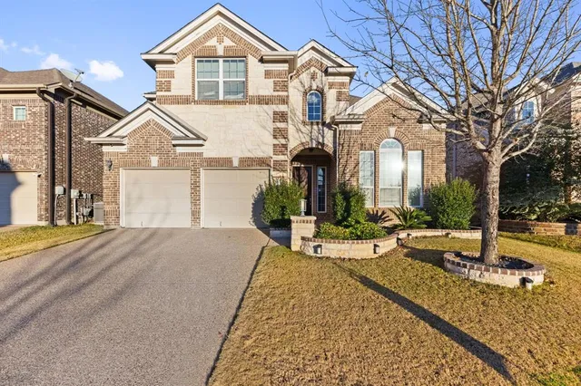 a view of a white house next to a yard with potted plants