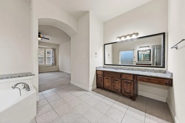 a spacious bathroom with a granite countertop sink and a mirror