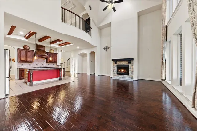 a view of an empty room with wooden floor and a fireplace