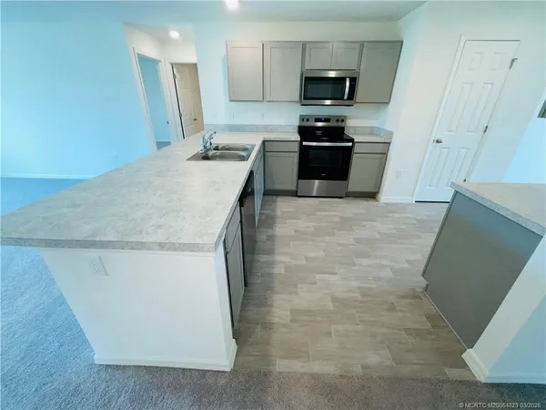 a kitchen with kitchen island sink stainless steel appliances and cabinets