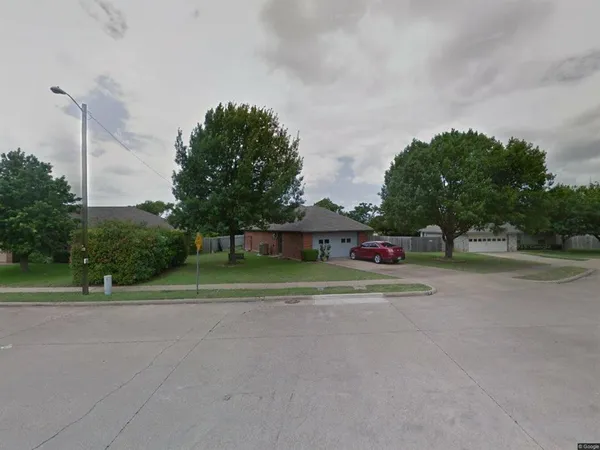 a front view of a house with a yard and trees