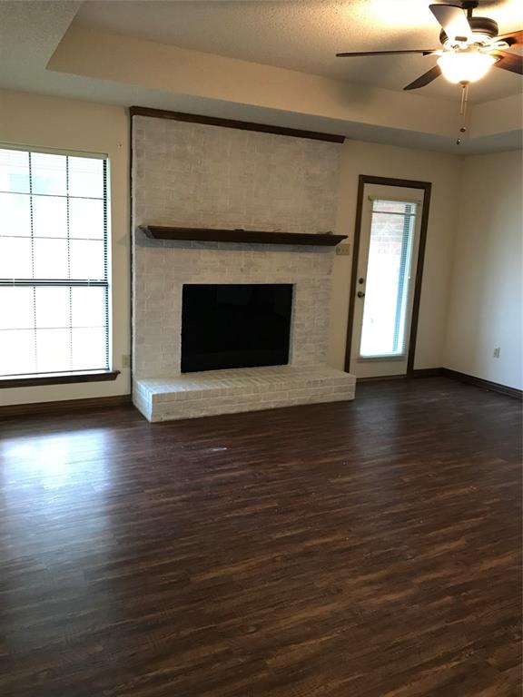 11 Marvin Garden Midlothian, TX 76065 - Photo 2 of 11 an empty room with wooden floor a fireplace windows and a fireplace