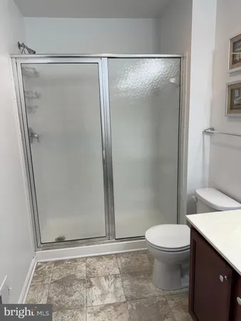 a bathroom with a glass door shower and toilet