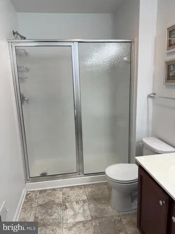 a bathroom with a glass door shower and toilet