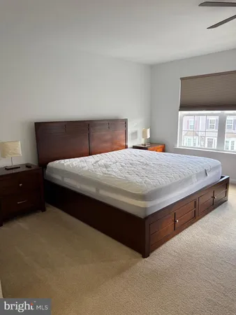 a bedroom with a bed couch and a flat tv screen