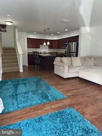 a living room with furniture and kitchen view