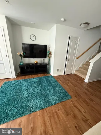 a living room with a bed furniture and a flat screen tv