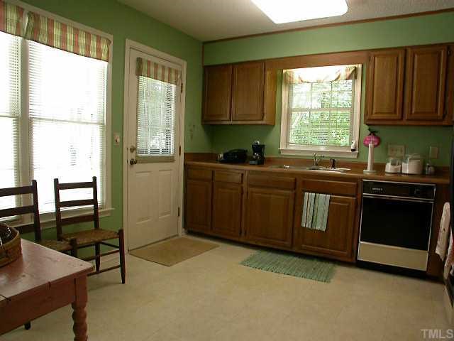 6902 Saxby Court Raleigh, NC 27613 - Photo 8 of 12 Spacious eat in kitchen. Oak Cabinets. Entry to patio New Stainless Steel look refrigerator. Stainless steel sink. Dishwasher, Oak Cabinets Window treatments remain....Ready to move in..