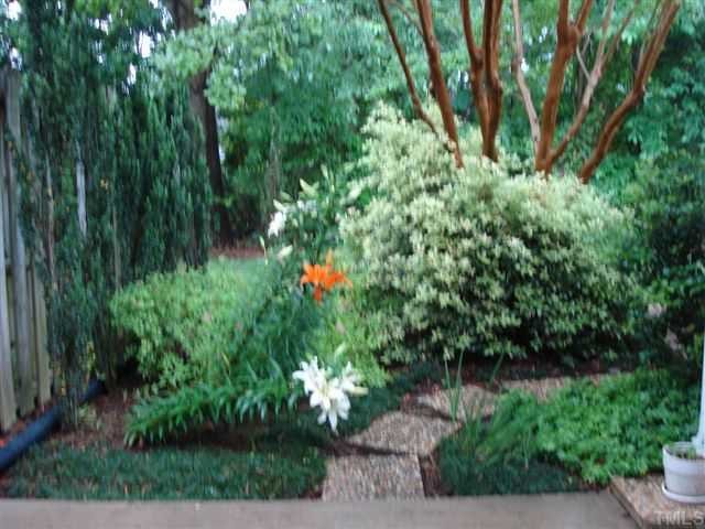 6902 Saxby Court Raleigh, NC 27613 - Photo 10 of 12 View of landscaping and lillies blooming from patio. Path to storage shed. Very private.....