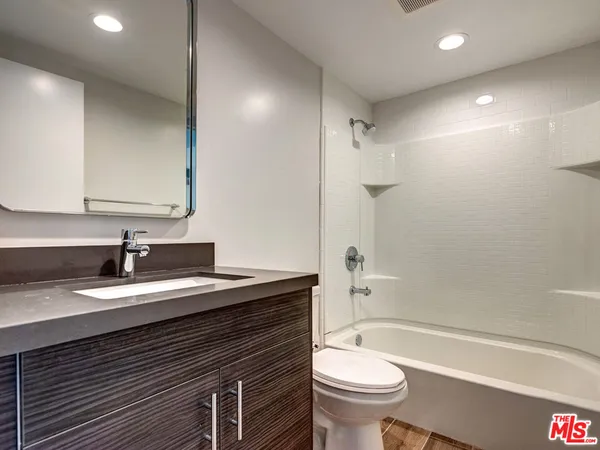 a bathroom with a granite countertop sink toilet and shower