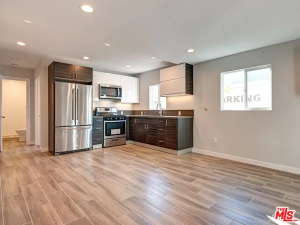 a kitchen with stainless steel appliances a refrigerator and a stove top oven
