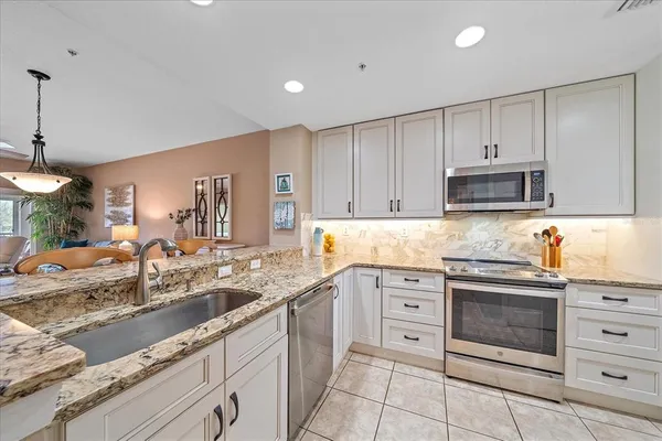 a kitchen with granite countertop a sink stove and cabinets