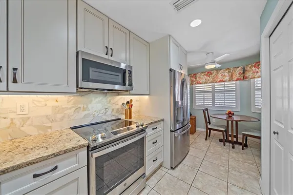 a kitchen with granite countertop a sink stove and cabinets