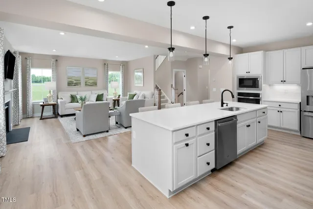 a kitchen with stainless steel appliances a stove a sink a microwave and cabinets