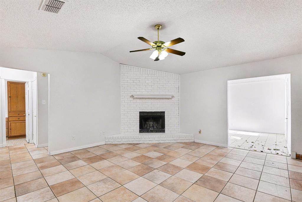 7912 Prairie Drive Watauga, TX 76148 - Photo 4 of 20 a view of an empty room with chandelier fan and fire place