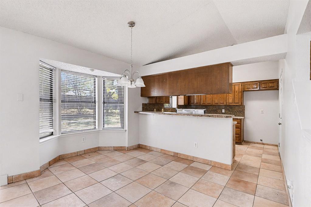7912 Prairie Drive Watauga, TX 76148 - Photo 6 of 20 a kitchen with stainless steel appliances granite countertop a refrigerator a sink dishwasher and white cabinets with wooden floor
