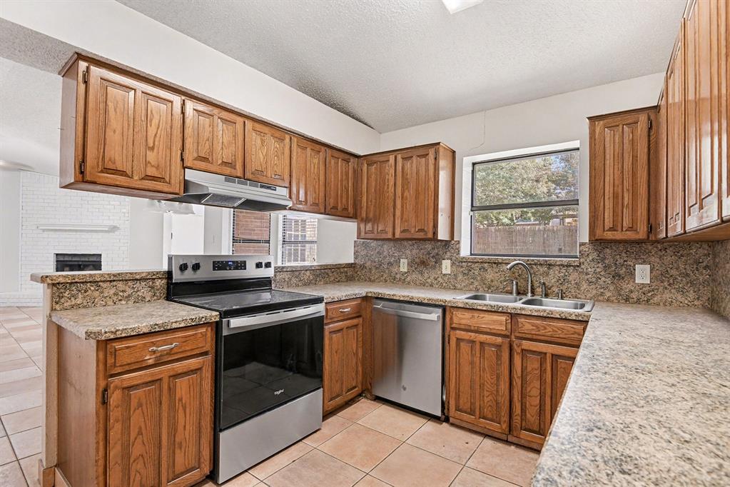7912 Prairie Drive Watauga, TX 76148 - Photo 10 of 20 a kitchen with stainless steel appliances granite countertop a stove sink microwave and cabinets