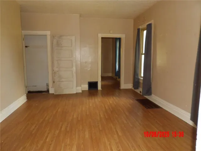 an empty room with wooden floor and closet