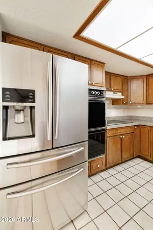 a kitchen with granite countertop a refrigerator and a stove