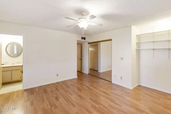 an empty room with wooden floor a exposed radiator and a window