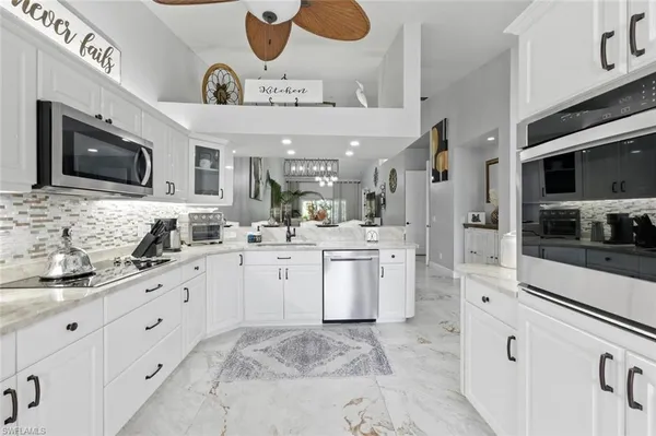 a kitchen with stainless steel appliances kitchen island granite countertop a sink and cabinets
