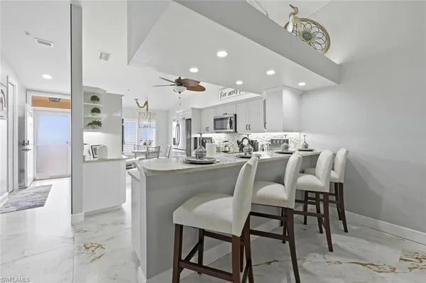 a living room with furniture chandelier and a window
