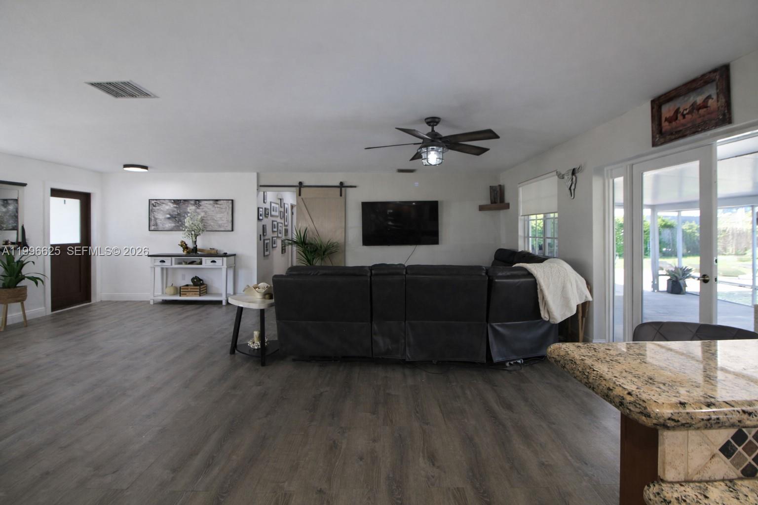 27420 Southwest 165th Avenue Homestead, FL 33031 - Photo 11 of 35 a living room with furniture and a flat screen tv