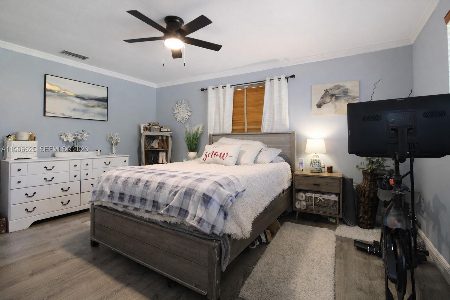 27420 Southwest 165th Avenue Homestead, FL 33031 - Photo 16 of 35 a spacious bedroom with a bed and a chandelier