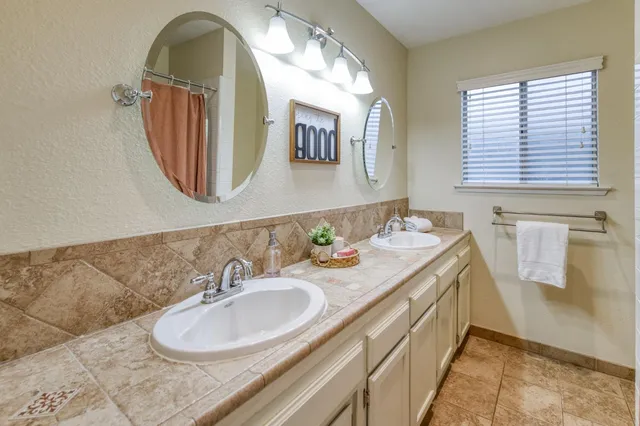 a bathroom with a granite countertop sink and a mirror