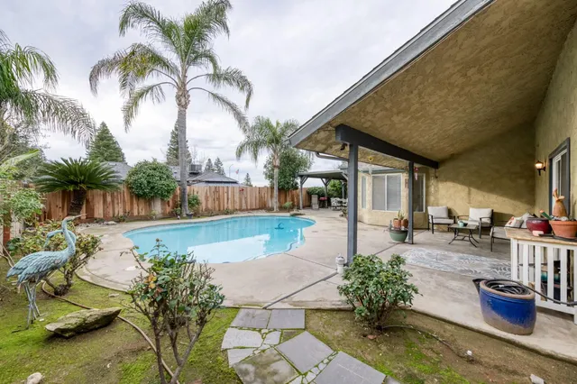 a view of a backyard with potted plants and swimming pool