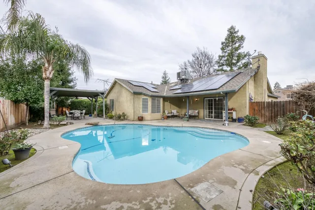 a view of a house with swimming pool and sitting area