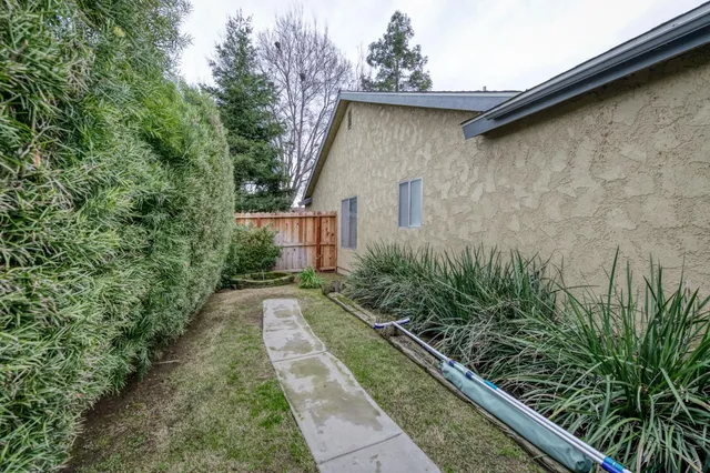 a pathway of a house with potted plants