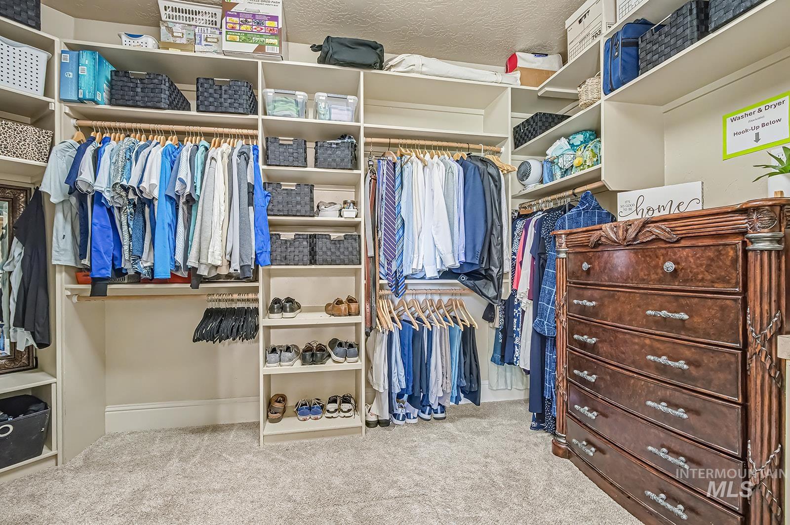 8751 West Rioja Street Star, ID 83669 - Photo 13 of 34 Expansive walk-in closet featuring extensive built-in shelving, multiple hanging rods, dedicated shoe storage, and a plush carpeted floor