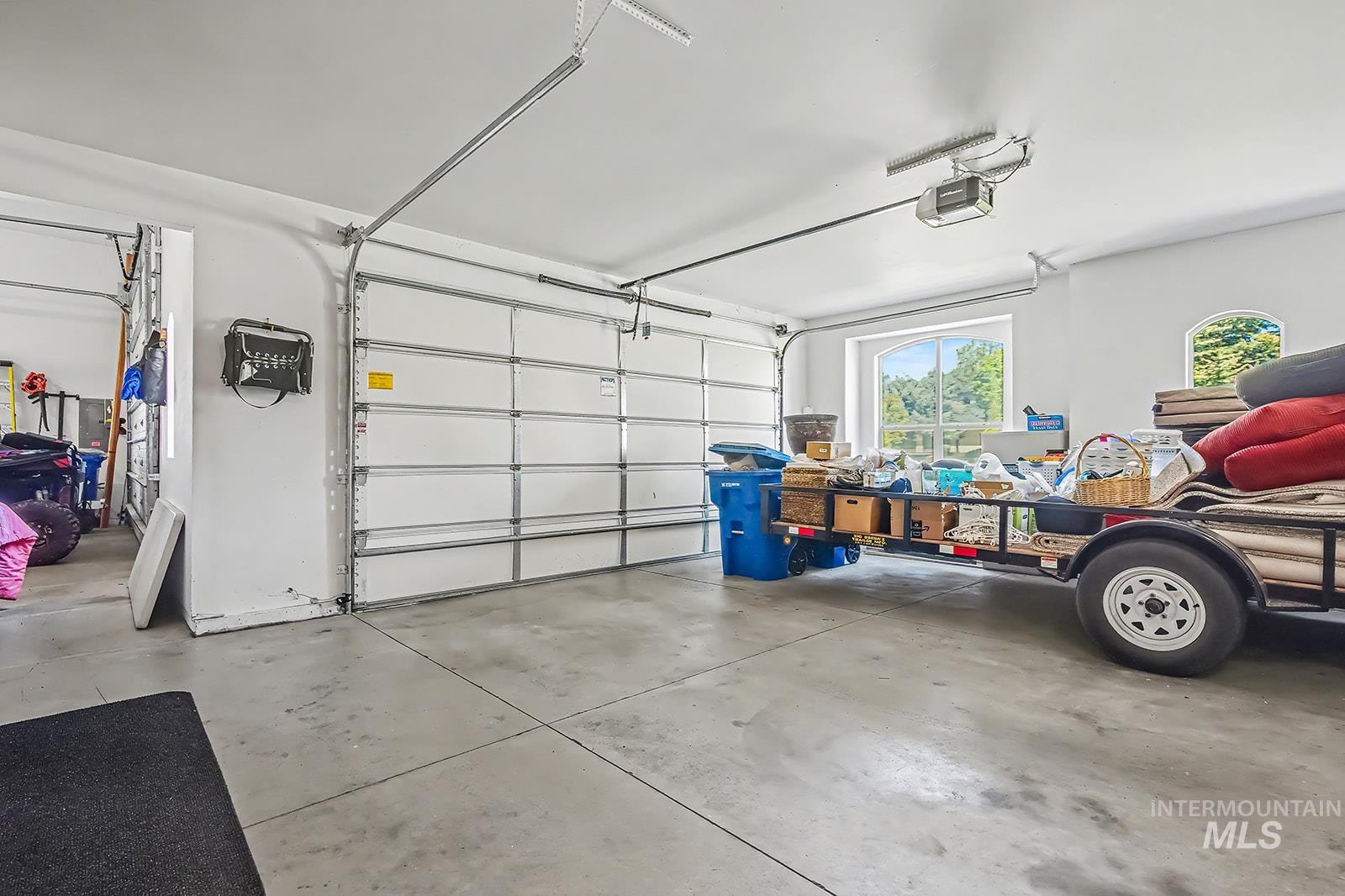 8751 West Rioja Street Star, ID 83669 - Photo 28 of 34 Spacious two-car garage featuring a concrete floor, white walls, and an arched transom window