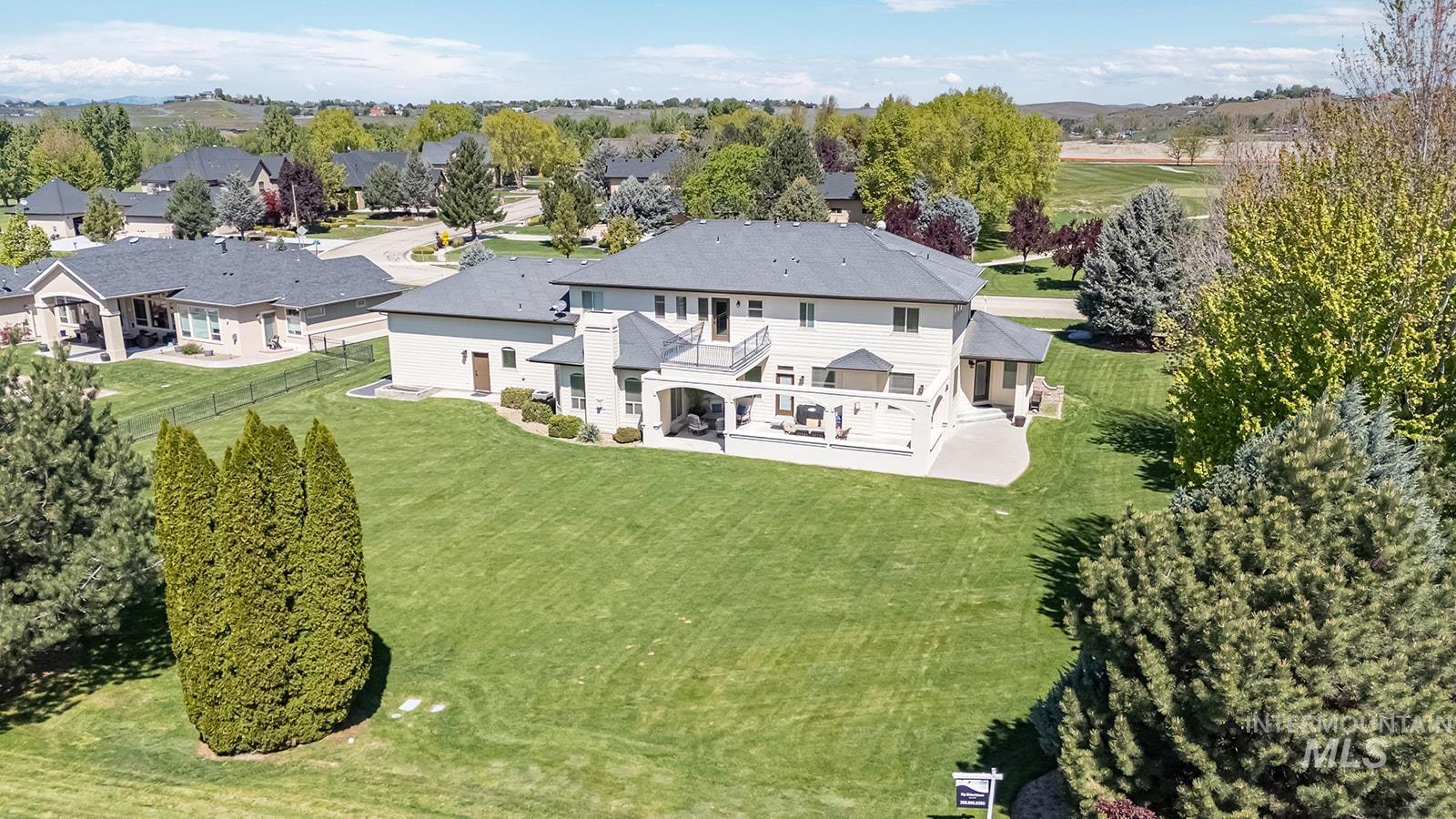 8751 West Rioja Street Star, ID 83669 - Photo 32 of 34 Spacious backyard featuring a manicured lawn, expansive multi-level deck, lower patio, mature landscaping, and a two-story residence with multiple outdoor access points
