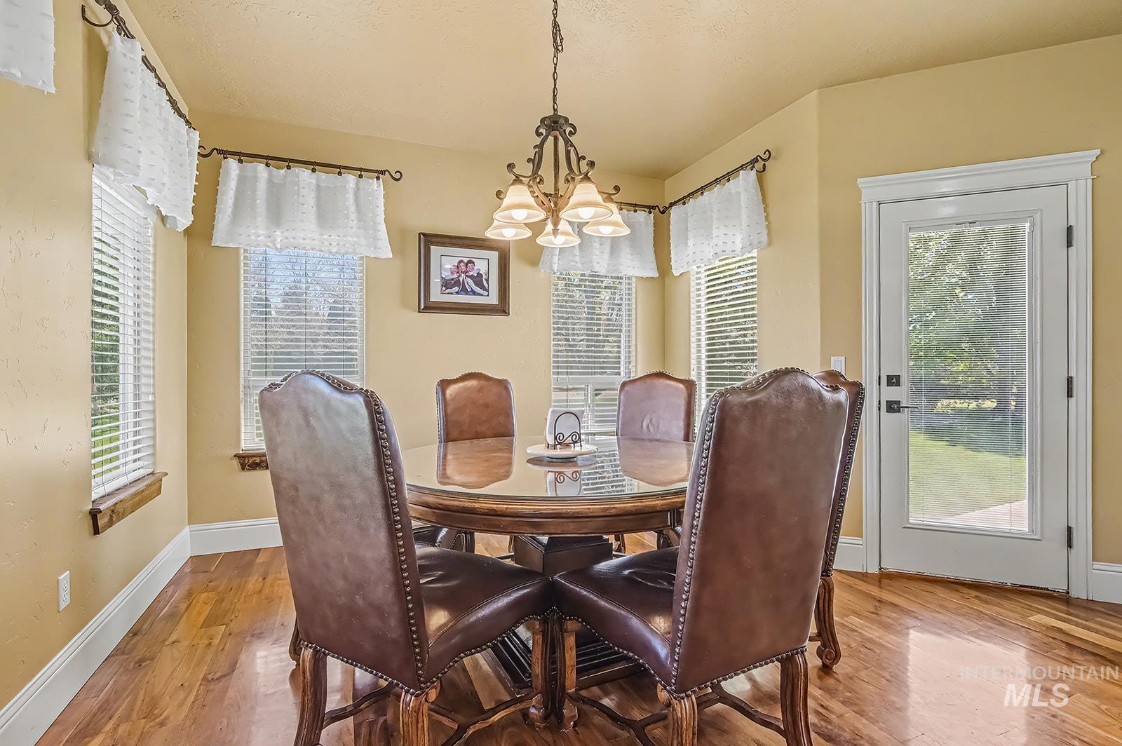 8751 West Rioja Street Star, ID 83669 - Photo 7 of 34 Dining space featuring wood-finish flooring and multiple windows with blinds