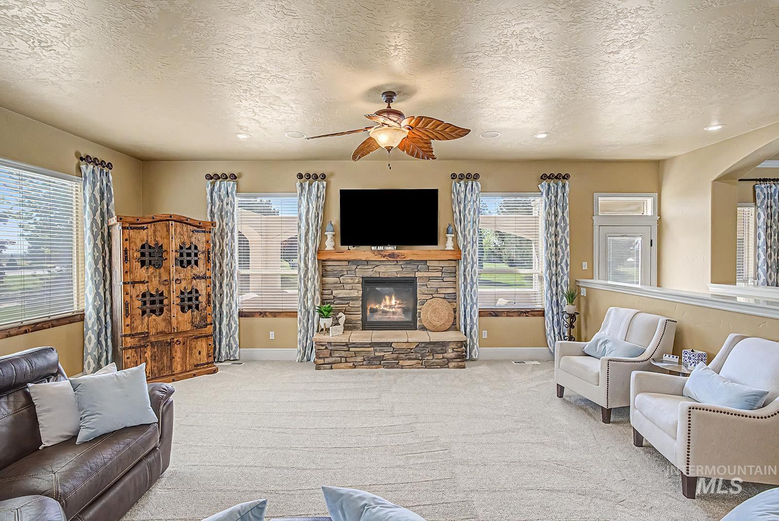 8751 West Rioja Street Star, ID 83669 - Photo 8 of 34 Spacious living area featuring a stacked stone fireplace with a substantial wood mantle