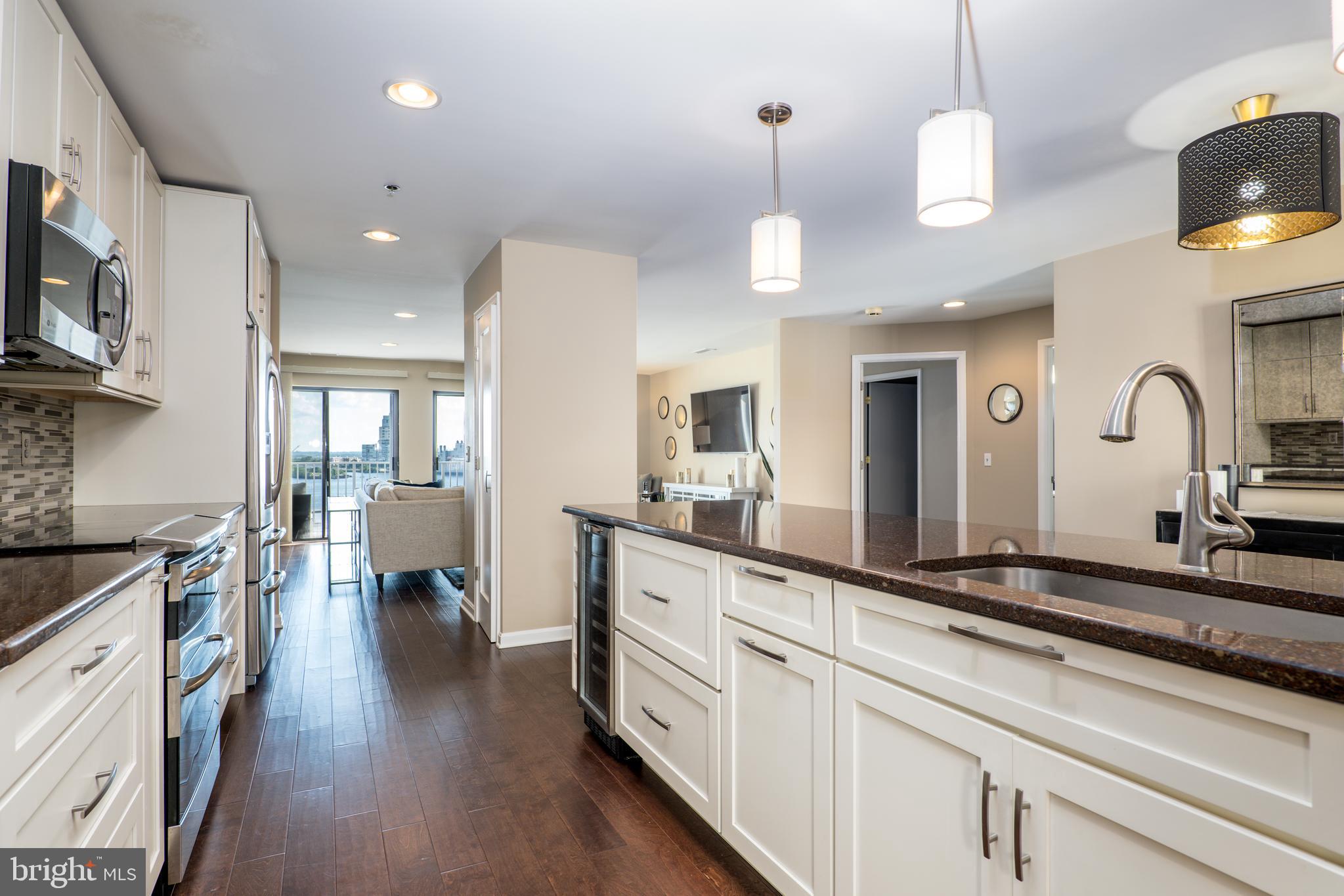 2702 Lighthouse Point East, Unit 637 Baltimore, MD 21224 - Photo 11 of 37 a large kitchen with stainless steel appliances kitchen island granite countertop a large island in the center