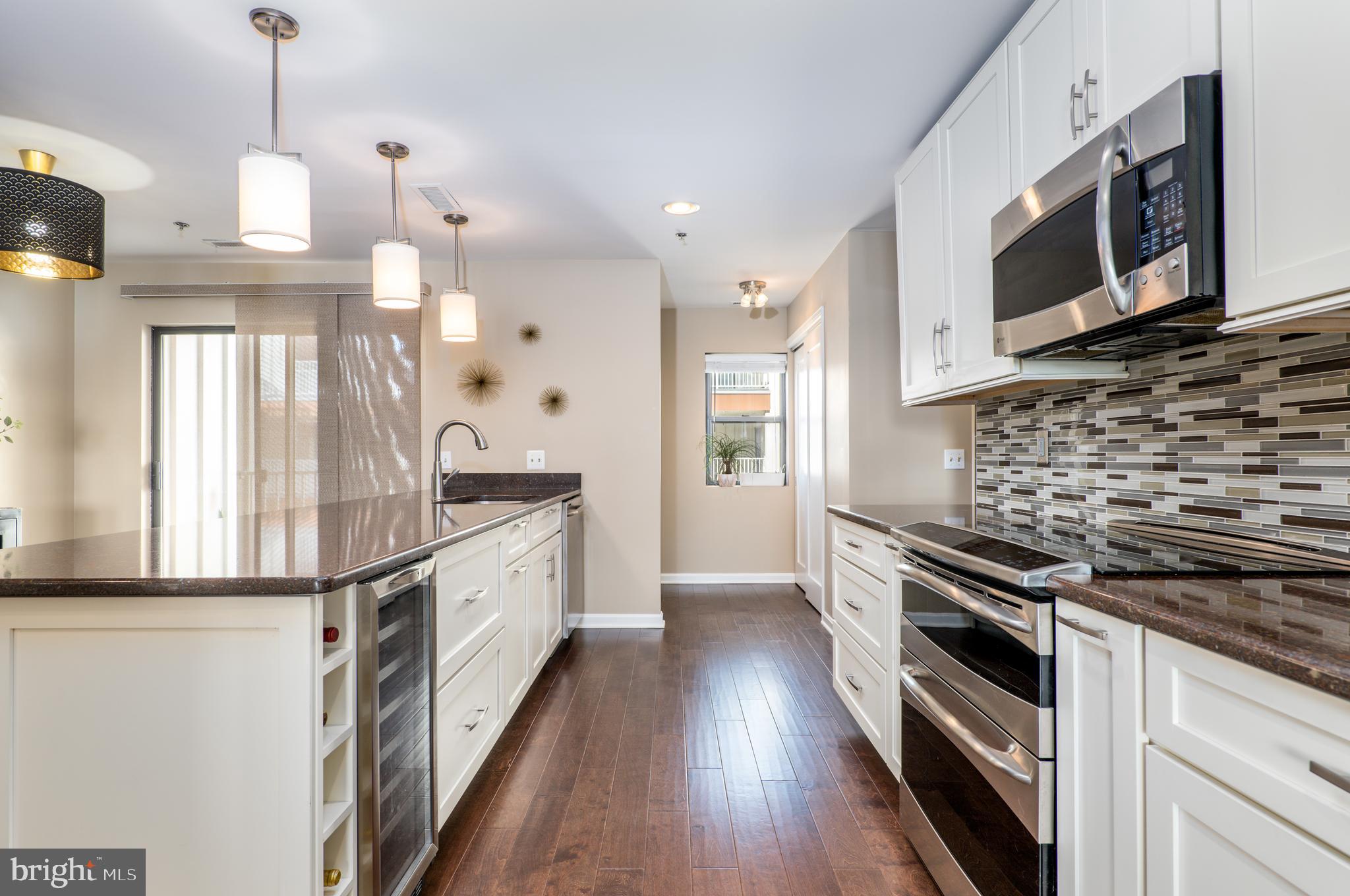 2702 Lighthouse Point East, Unit 637 Baltimore, MD 21224 - Photo 12 of 37 a kitchen with stainless steel appliances kitchen island granite countertop a stove a sink and a refrigerator