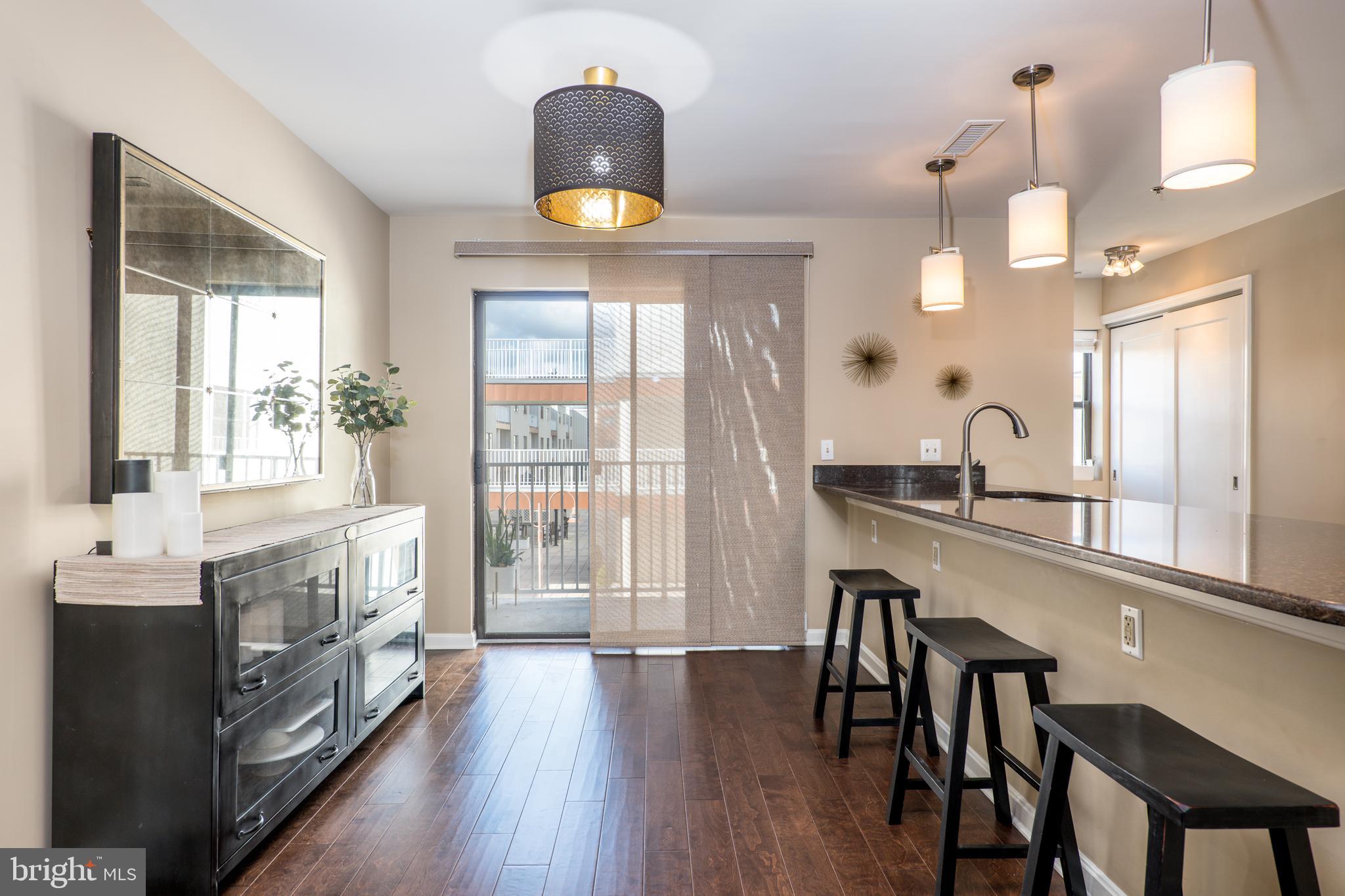 2702 Lighthouse Point East, Unit 637 Baltimore, MD 21224 - Photo 14 of 37 a large kitchen with a table and chairs