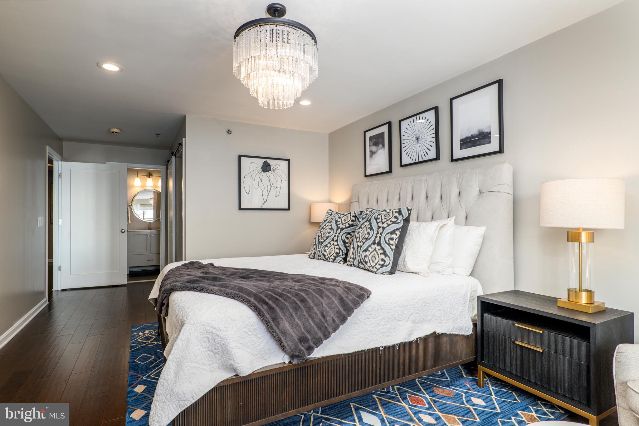 2702 Lighthouse Point East, Unit 637 Baltimore, MD 21224 - Photo 20 of 37 a bedroom with bed and a night stand