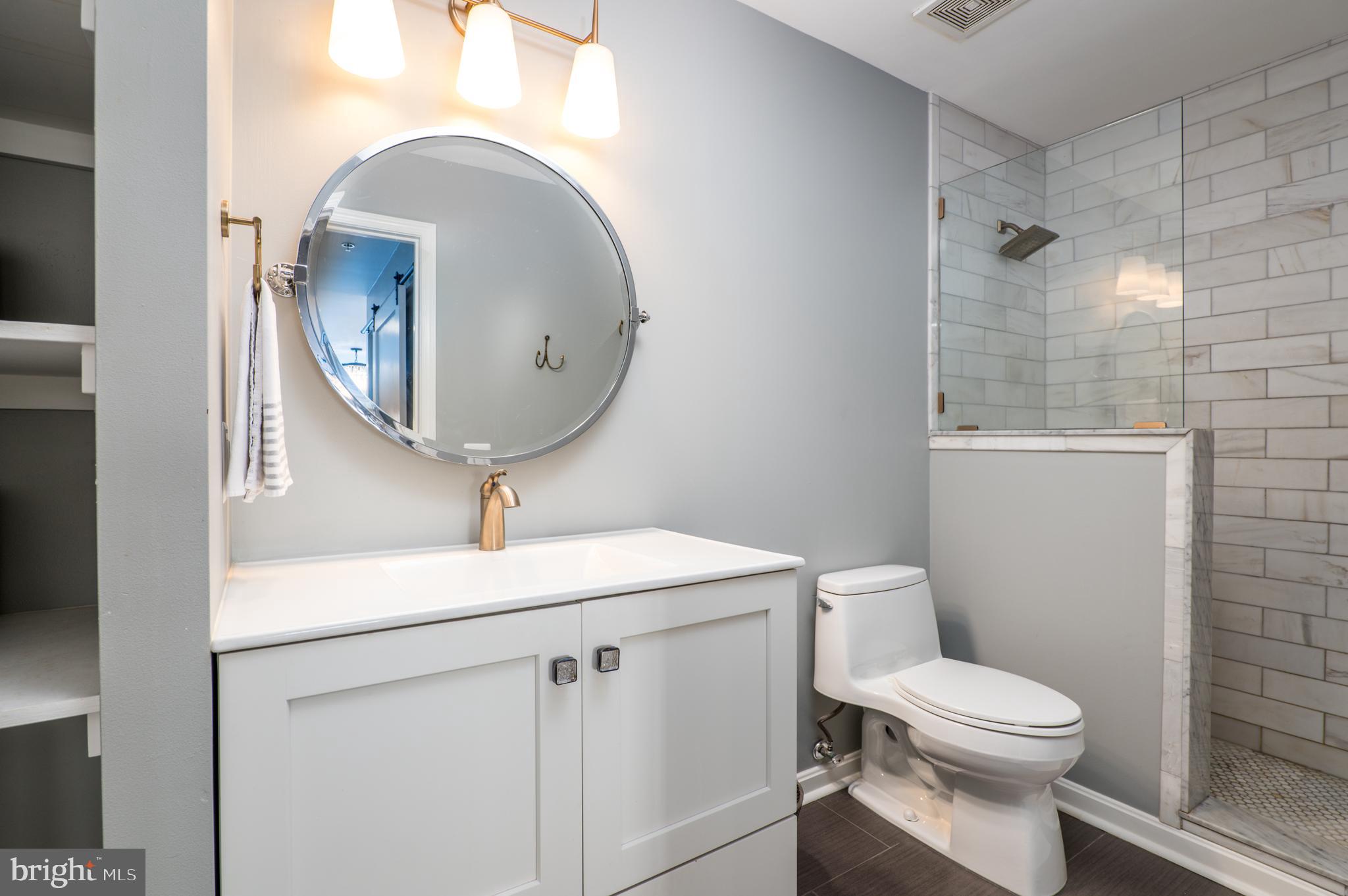 2702 Lighthouse Point East, Unit 637 Baltimore, MD 21224 - Photo 21 of 37 a bathroom with a toilet a sink and mirror