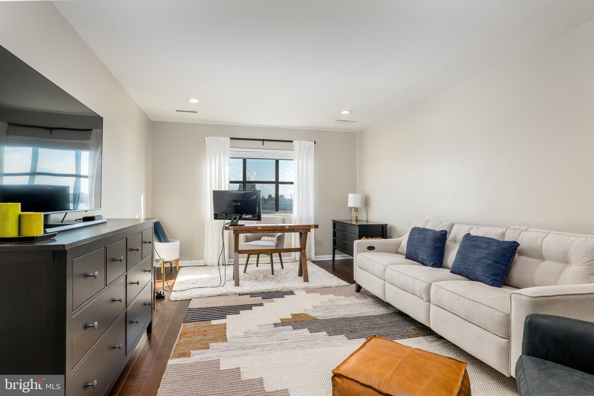 2702 Lighthouse Point East, Unit 637 Baltimore, MD 21224 - Photo 23 of 37 a living room with furniture and a window